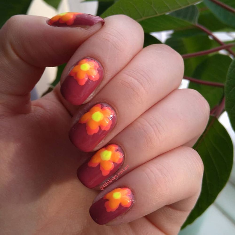 Close up of flowered short nail design with Burgundy and Sunshine Nail Art