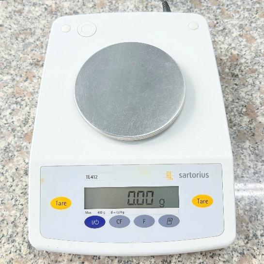 A white electronic scale with a round object on it

AI-generated content may be incorrect.
