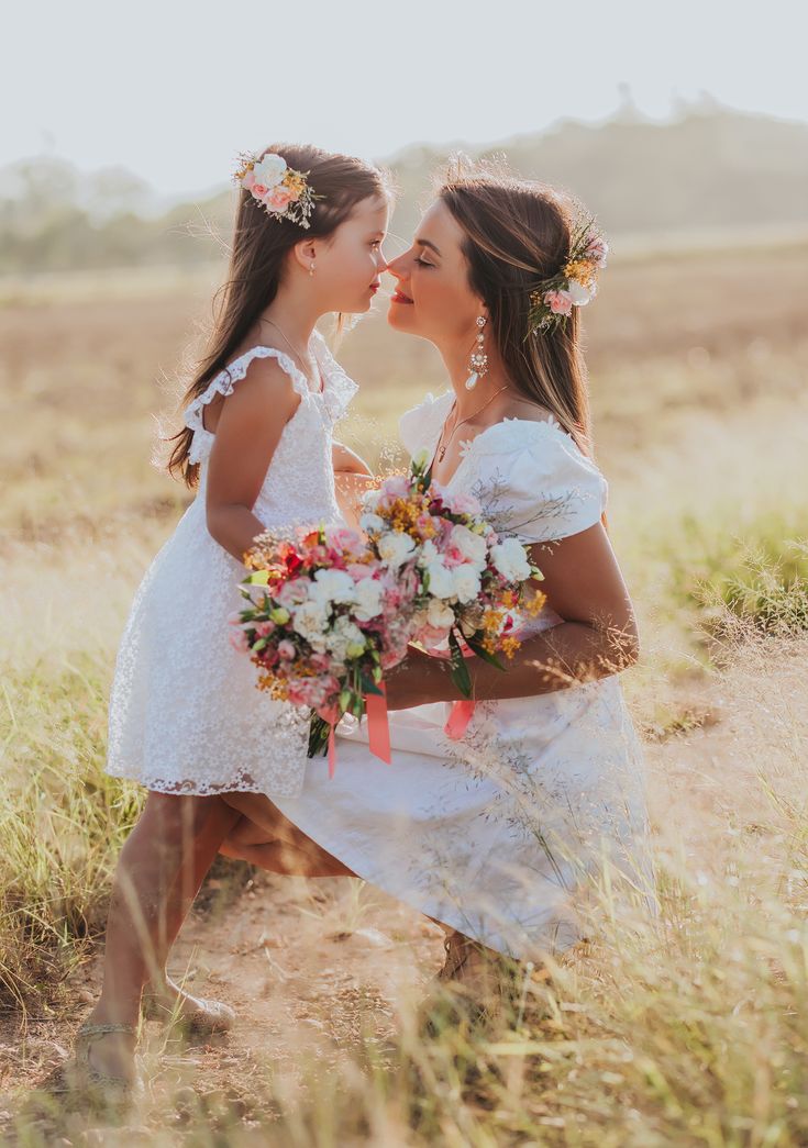 Heartwarming Mother's Day shoot with a mother sitting in front of her daughter, smiling and holding flowers