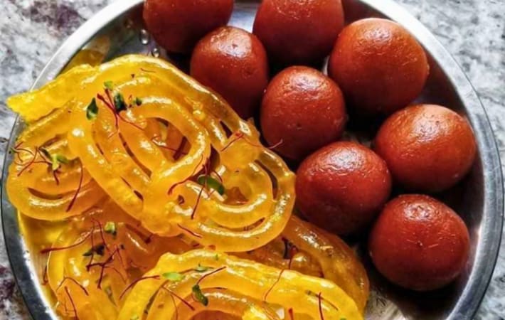 Indian sweets - jalebi and gulab jamun served on a plate.