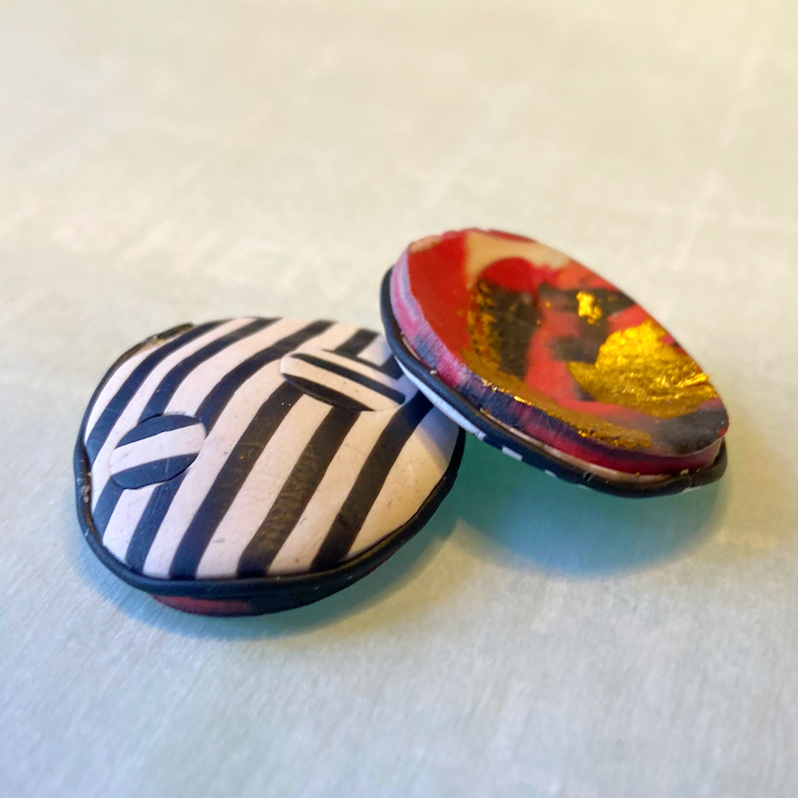 Black and white polymer clay earring, showing curves and backing