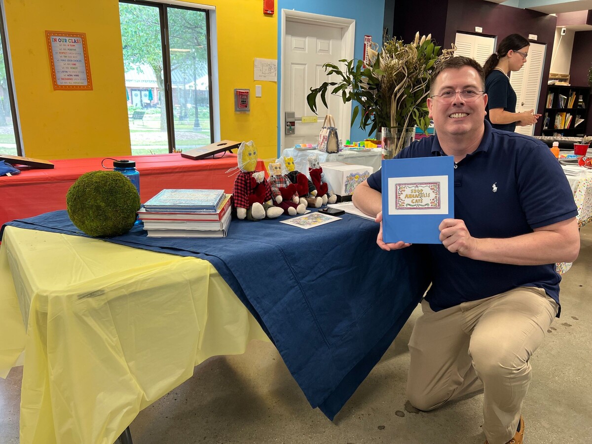 Annapolis resident Charlie Mazurek will host a book release party Sunday for his first children’s story, called “Shop Annapolis Cats.” Mazurek is pictured above with his book and homemade cat stuffed animals. (Courtesy of Charlie Mazurek)