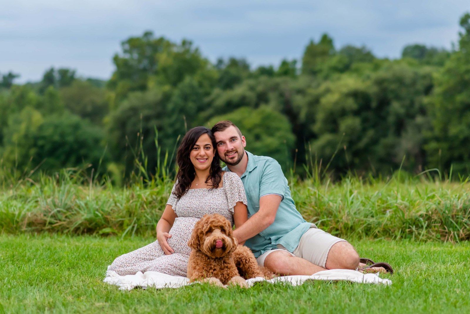 Pregnant couple enjoying a joyful moment in the garden with their pets for a maternity shoot