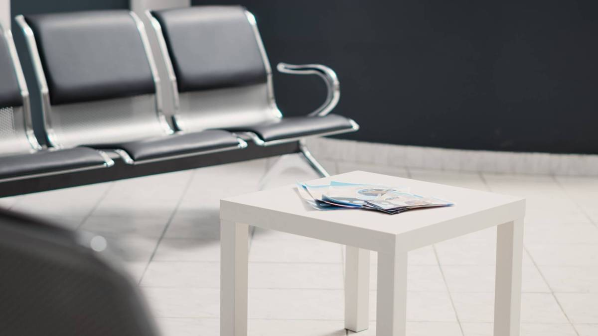 A stock photo of black chairs in a waiting room