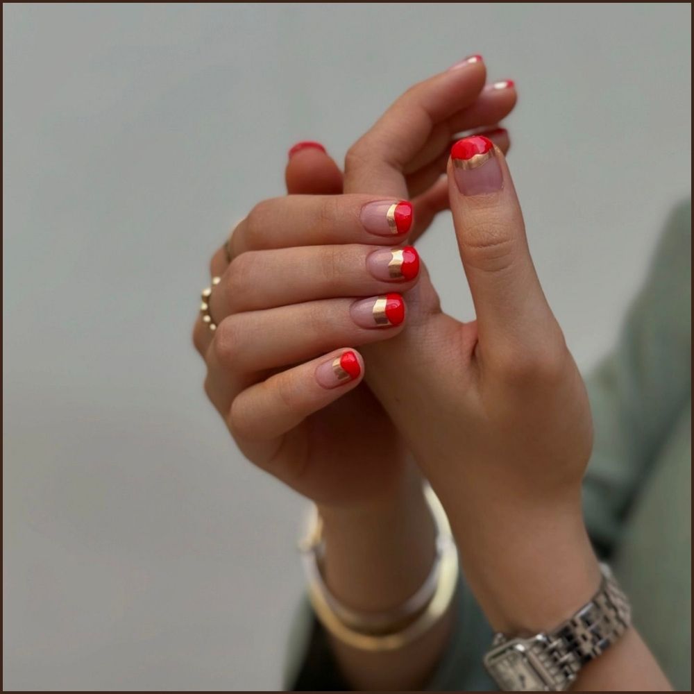 Close up of hands having Christmas red nails with Gold-Tipped Red Glamour