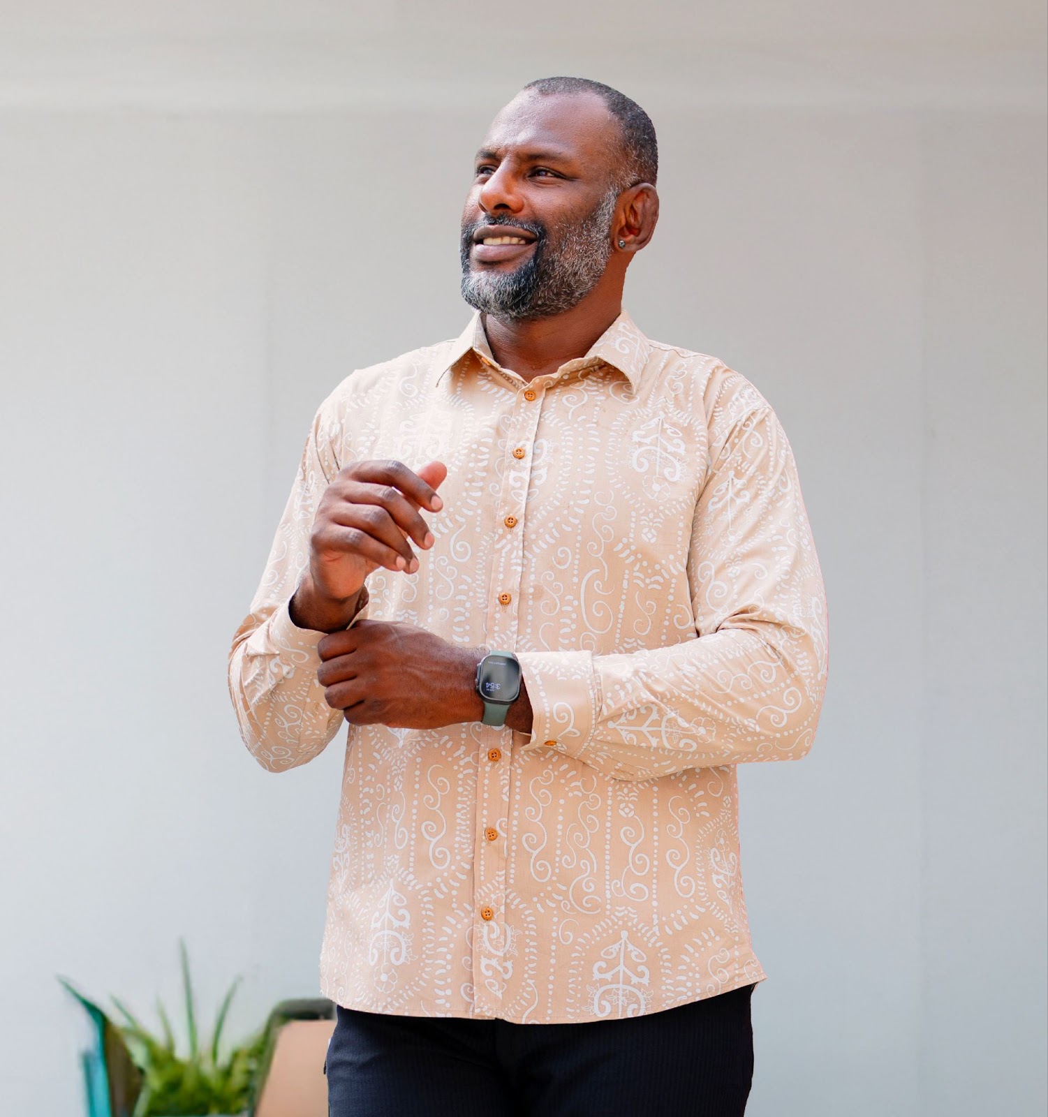 An image showing long sleeved men's batik shirt in tan petola from batik boutique, standing in a office