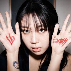 This contains an image of Lee Young Ji with two hands painted red and no entry written on their palms, holding her hand up in front of her face