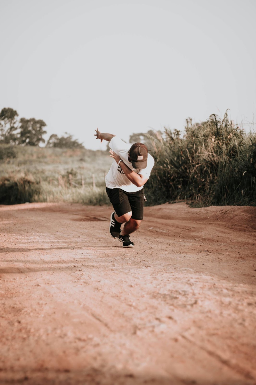 Man Running Uphill on Dirt Trail