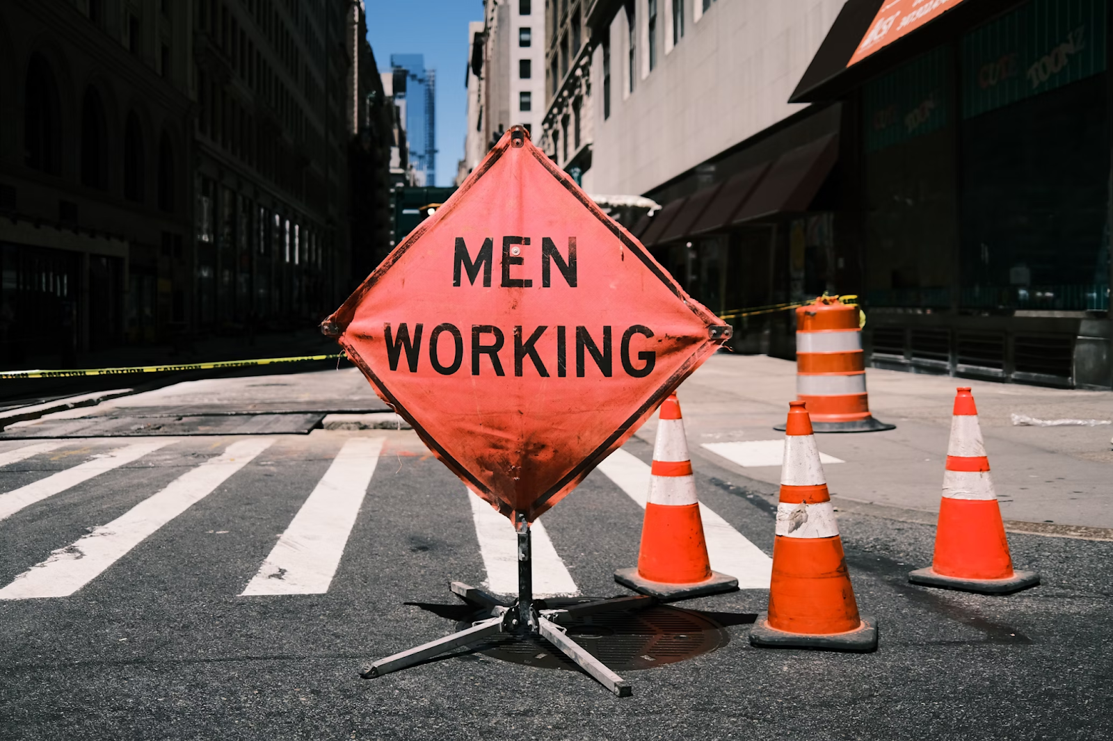 Construction site risk management in action with warning sign and safety cones.