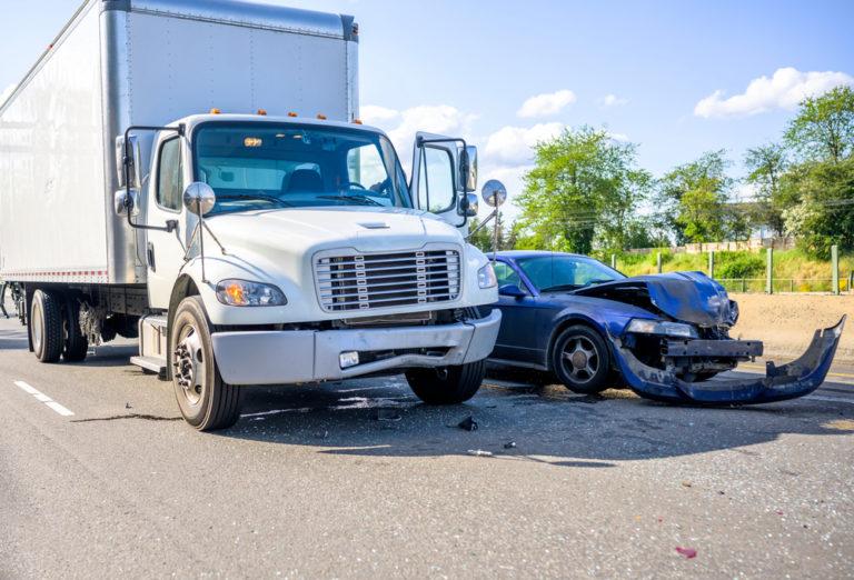 Truck accident scene with a car.