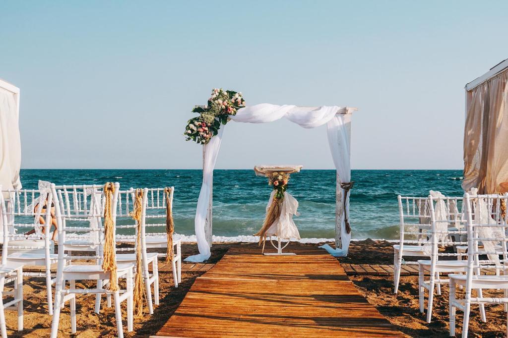 Wedding ceremony setup with chairs and floral arch on Lara Beach, Antalya