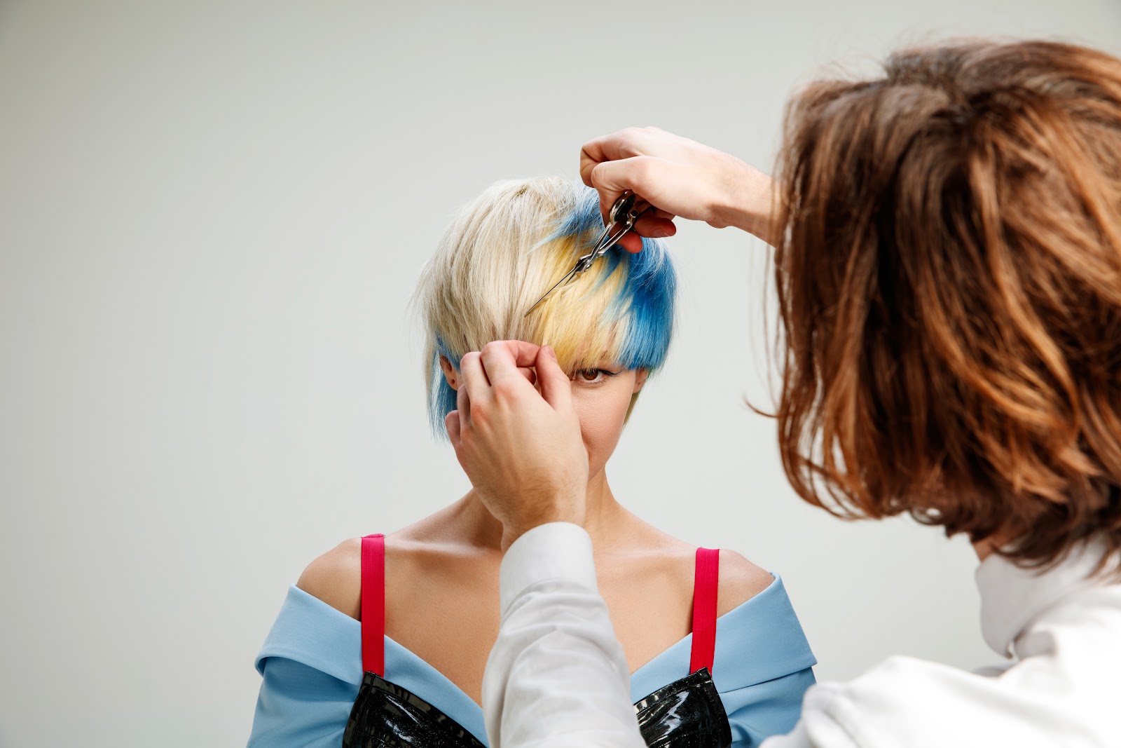 Stylist color correcting the hair of a client