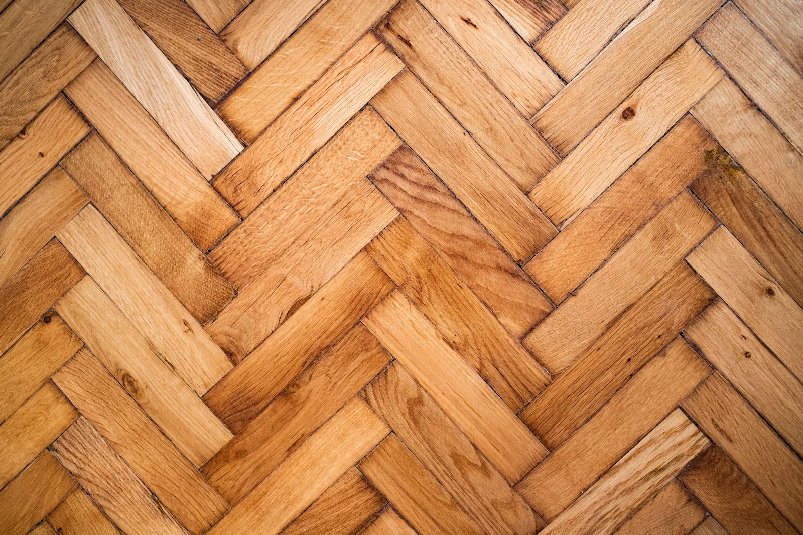 A vintage wooden floor designed with a Herringbone pattern.