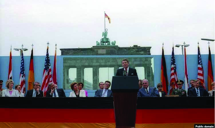 A person standing at a podium with flags

AI-generated content may be incorrect.