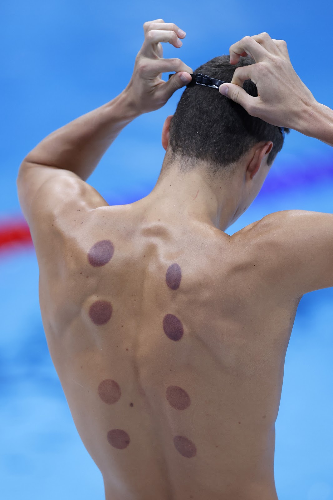 Marks are seen on the back of a swimmer during aquatics training ahead of the Tokyo 2020 Olympic Games in Tokyo, Japan, on July 22, 2021. | Source: Getty Images