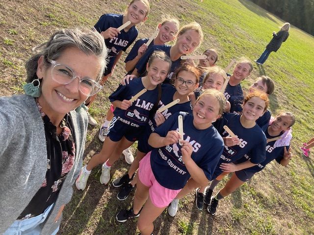 image of the principal with students on the cross country team