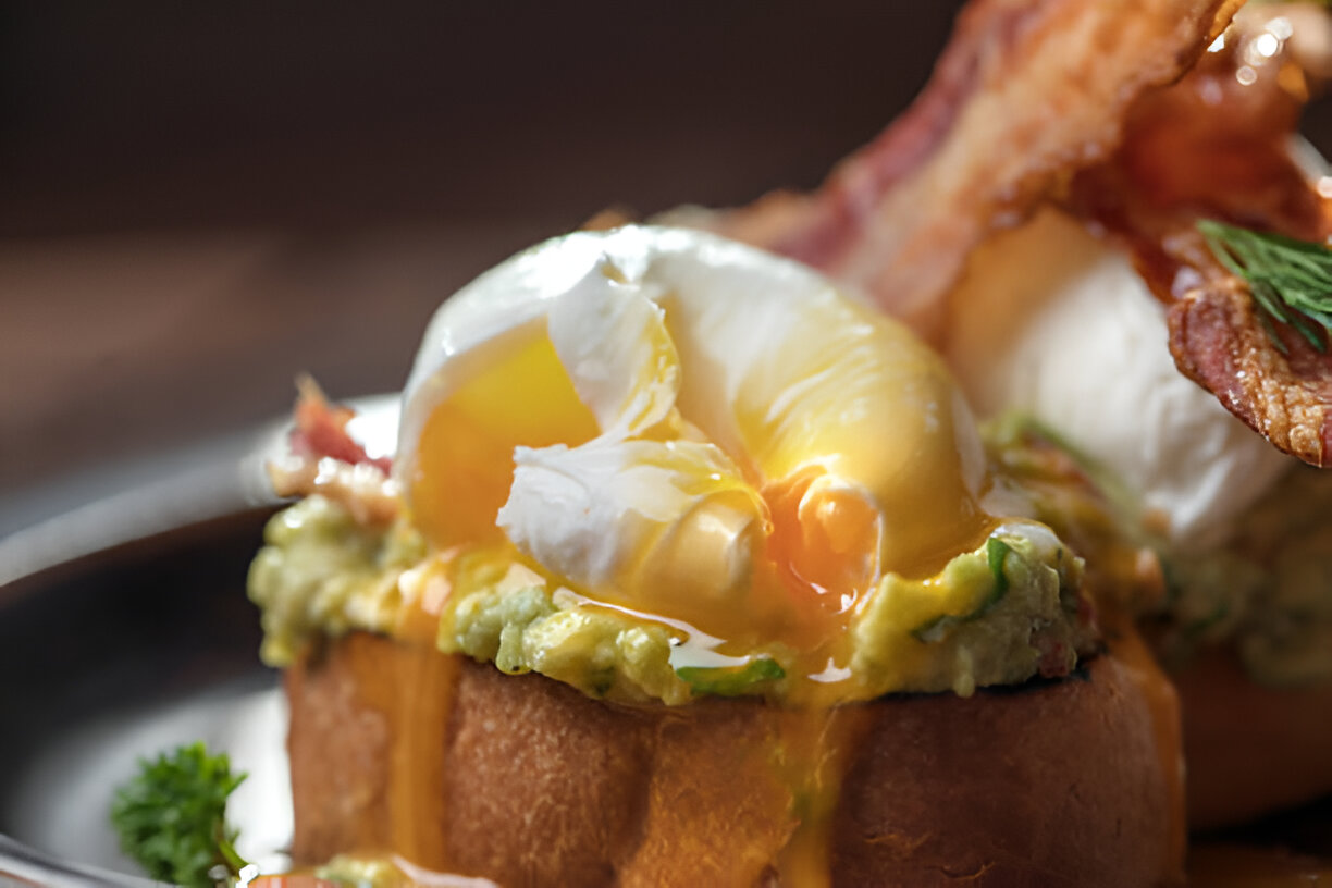 Eggs benedict yang dibuat dari english muffin, poached eggs, daging ham, dengan saus hollandaise