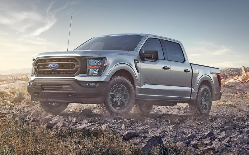 A silver truck driving on a rocky terrain

Description automatically generated