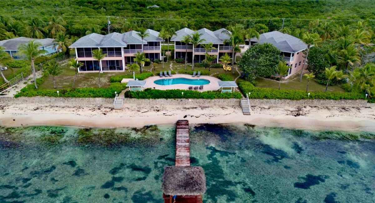 Aerial view of beachfront villas in East End, Grand Cayman, featuring a private pool and ocean access, perfect for snowbirds seeking a peaceful retreat.