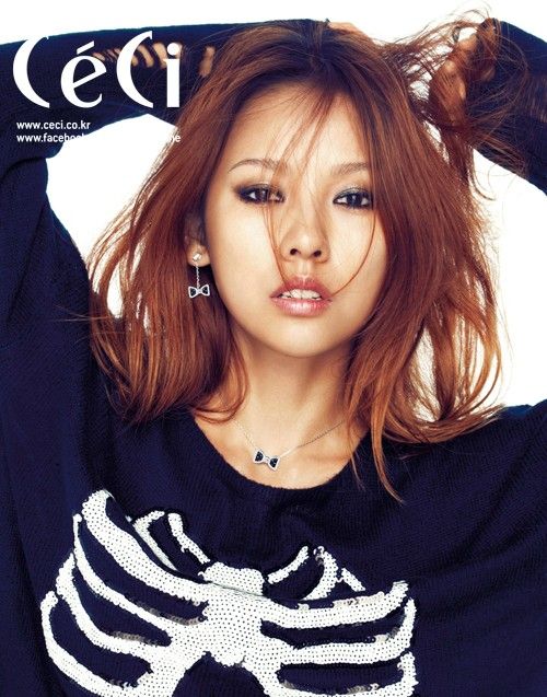 A picture of lee hyori wearing a blue dress and a brown hair with her hand on her head