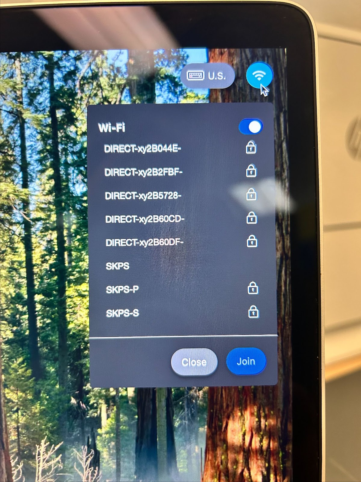 MacBook login page highlighting wifi symbol and a drop down menu with each available network.