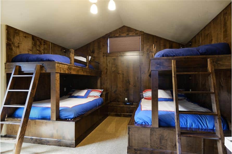 Bunk room with a cathedral ceiling, carpet flooring, and built-in bunk beds.