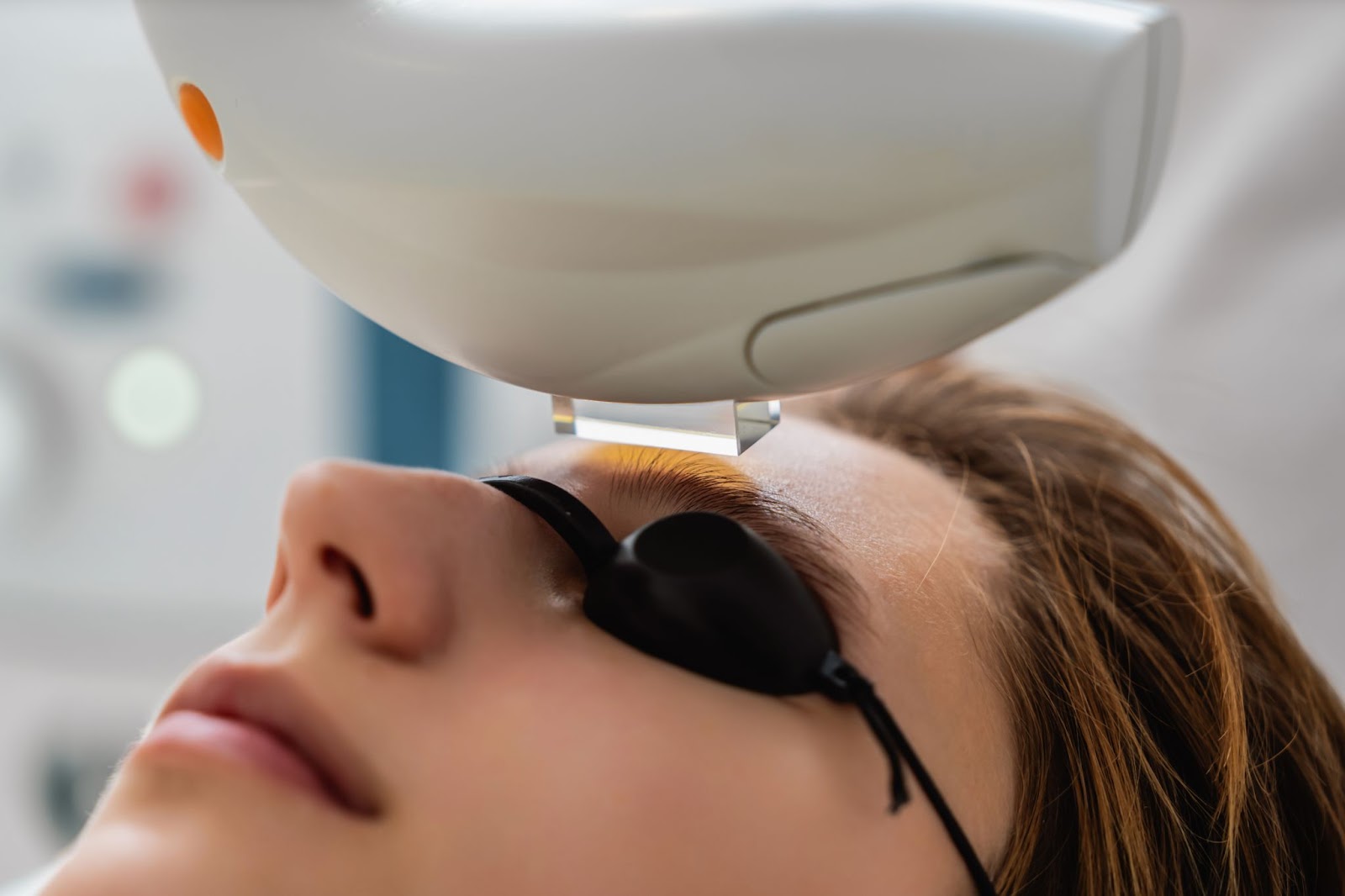 A closeup of a woman wearing goggles to protect her eyes during an IPL treatment for dry eyes