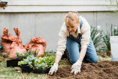 landscaping mistakes to avoid while remodeling your outdoor living space gardener checking soil quality in backyard custom built michigan