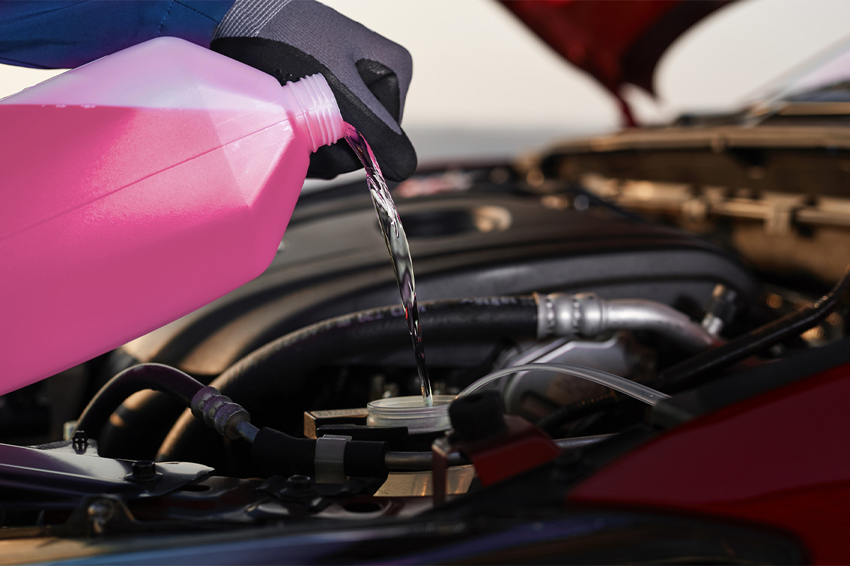 Filling engine coolant and anti-freeze in the radiator reservoir to keep the engine cool.