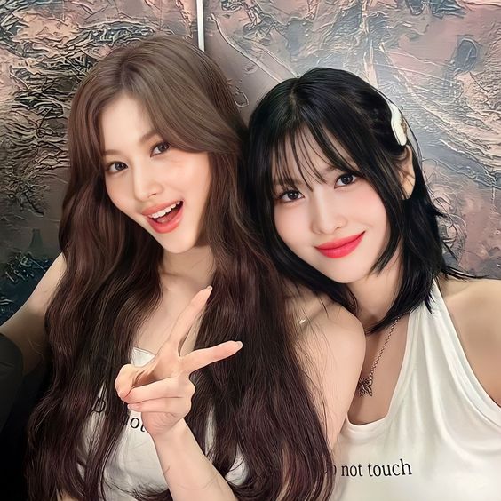 A picture ofd TWICE members Sana and Momo taking a selfie 