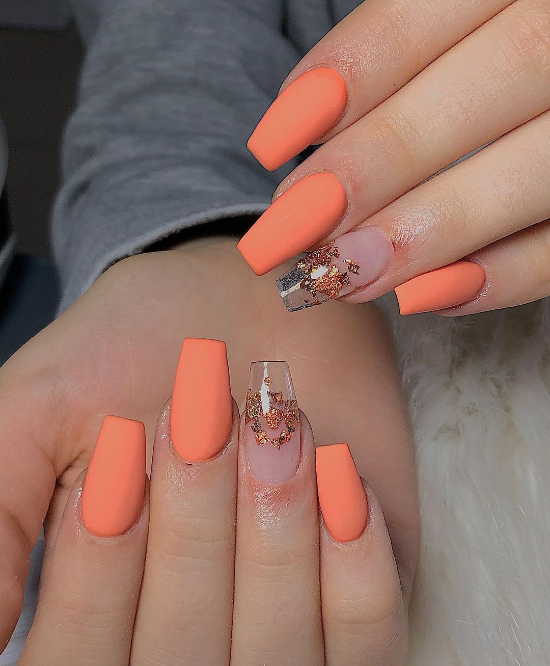 Close up of nails with glittery orange nails having Velvet Orange Nails