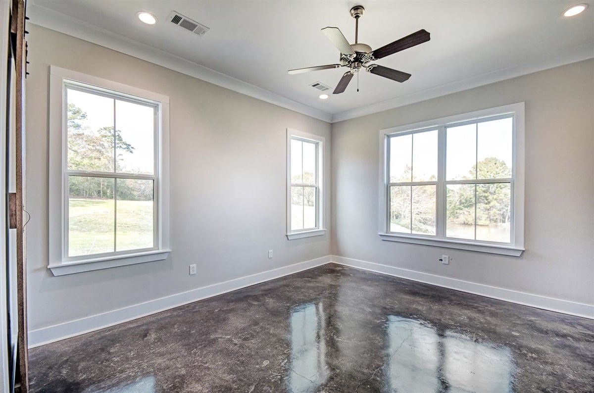 Primary bedroom with gray walls, white-framed windows, and marble flooring.