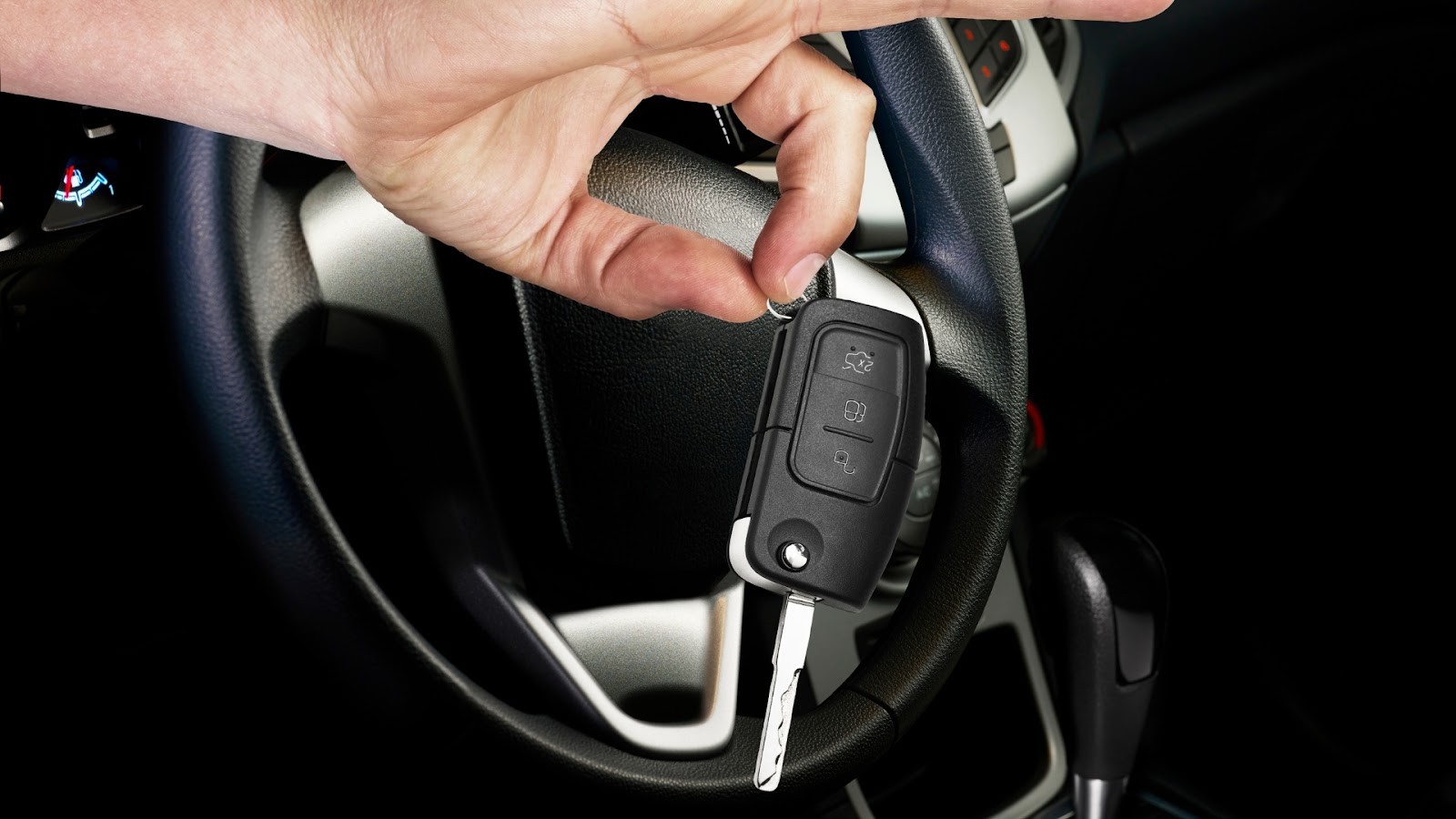 A hand holding a replacement key fob, solving lost car key problems.