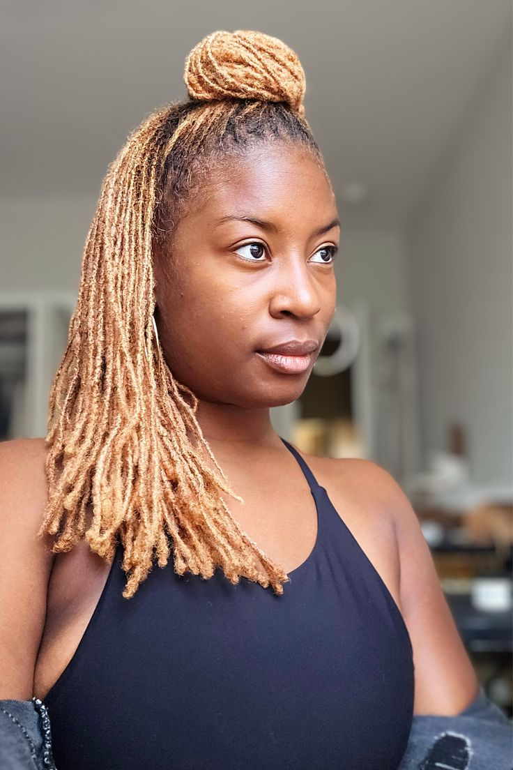 a lady rocking large microlocs with a bun