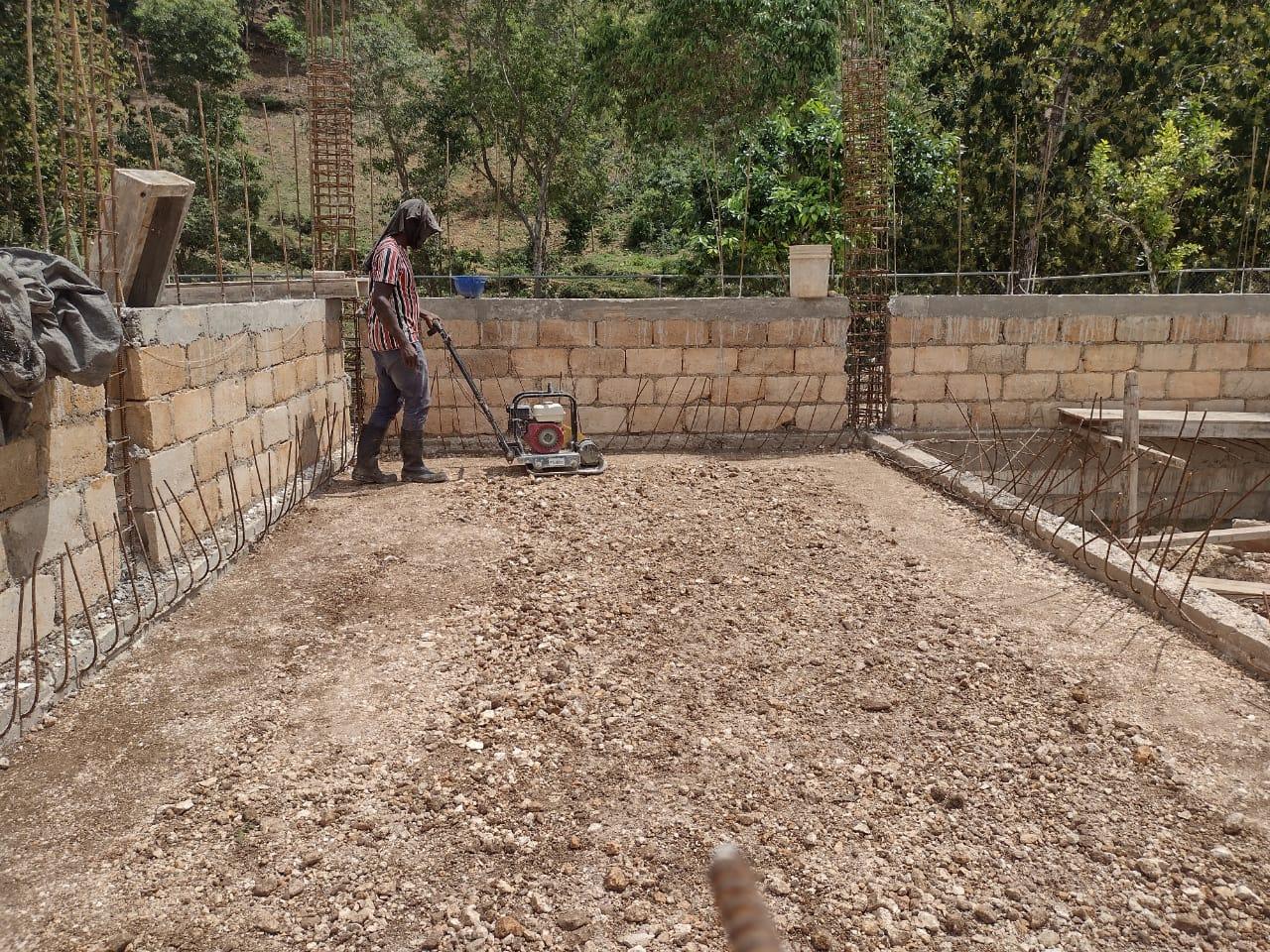 A person using a machine to level the ground

Description automatically generated