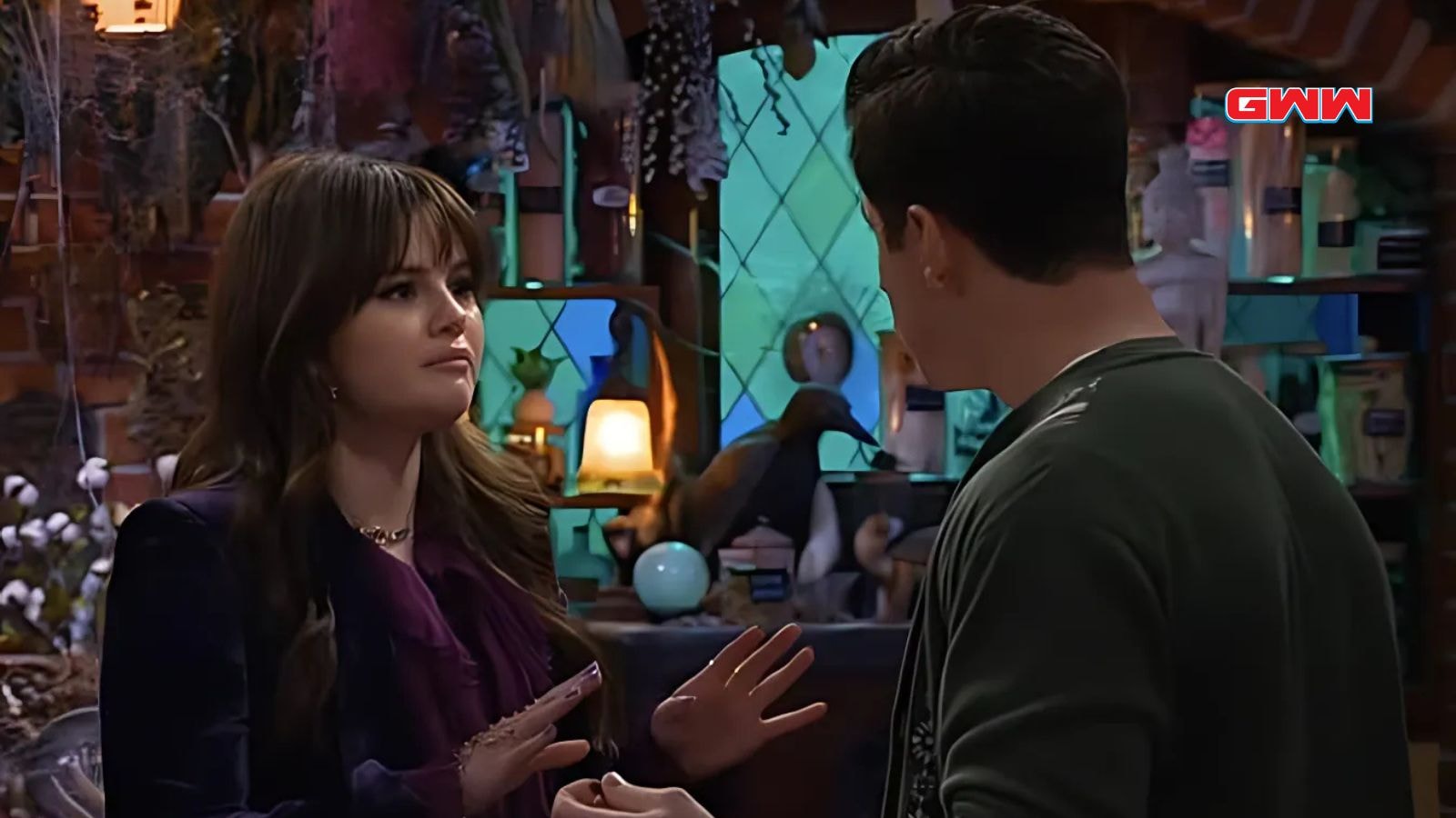 Selena Gomez and David Henrie in a serious conversation inside a magical room