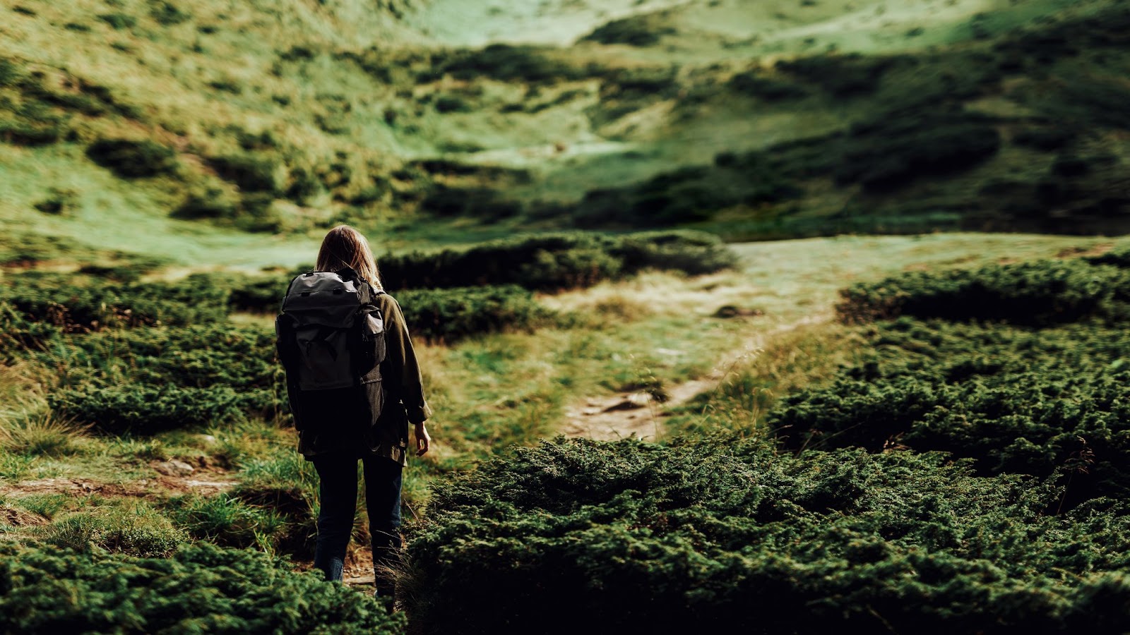 Portrait of a girl with a backpack in the mountains