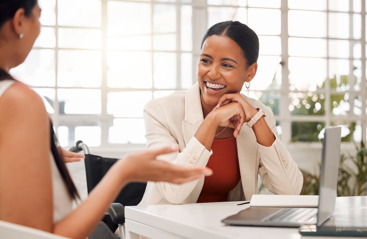 Case management workflow: employee in a wheelchair talking to her colleague