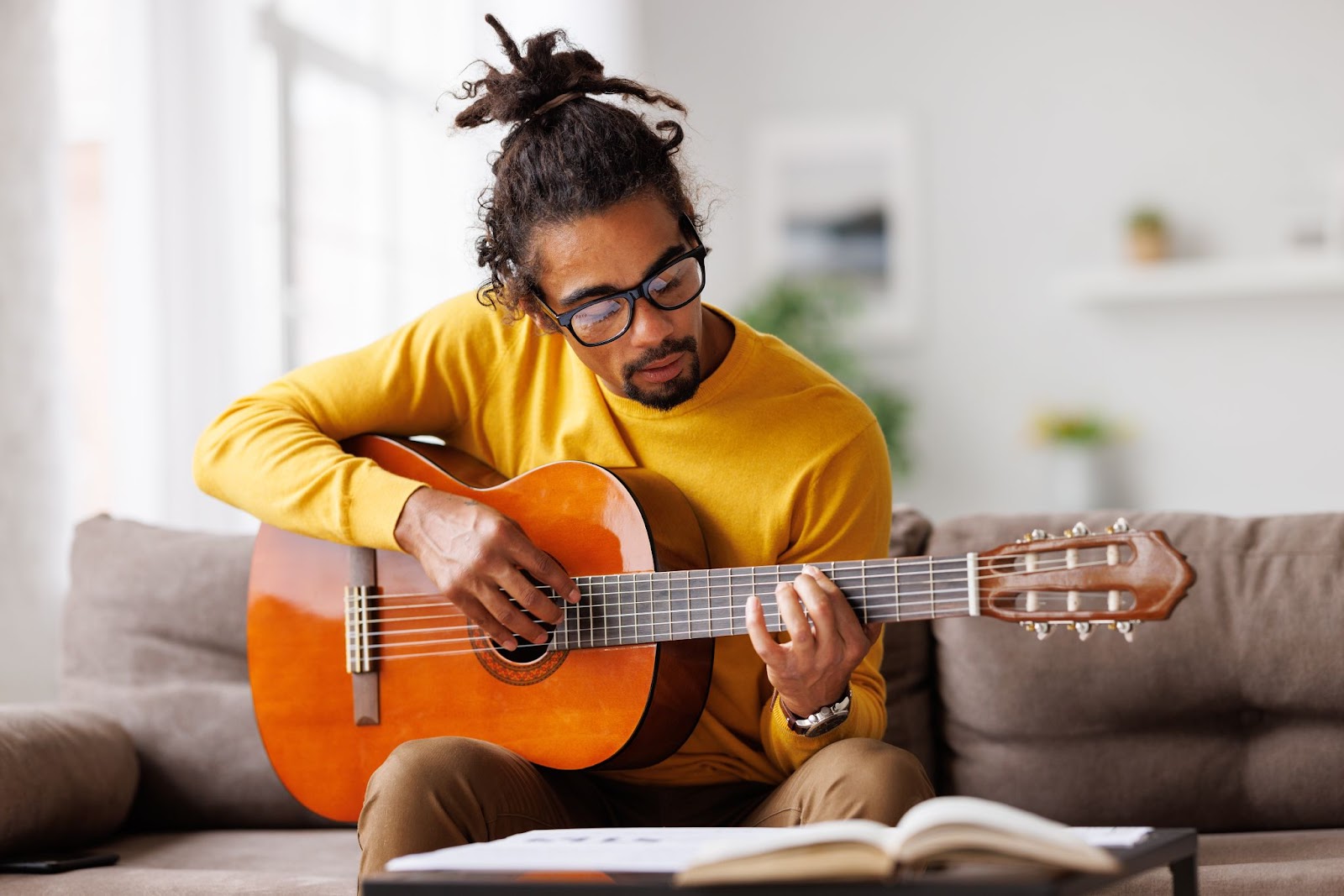 A person playing guitar in a living room.