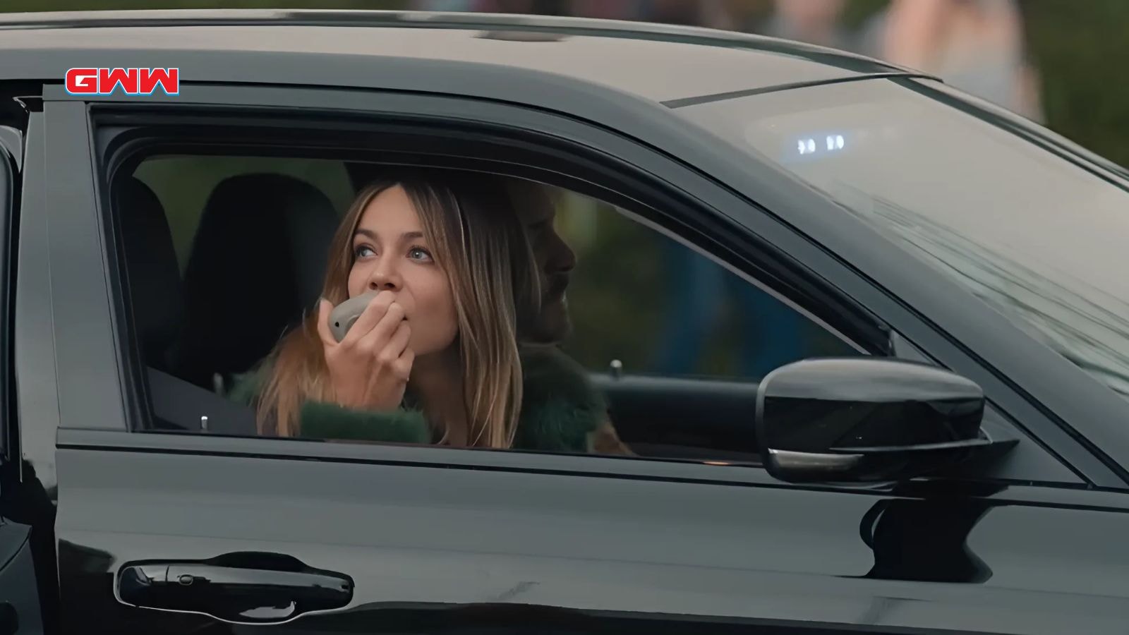 Morgan speaking into a police car's megaphone