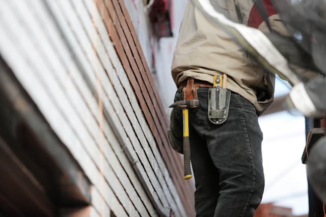 Construction working standing on side of home