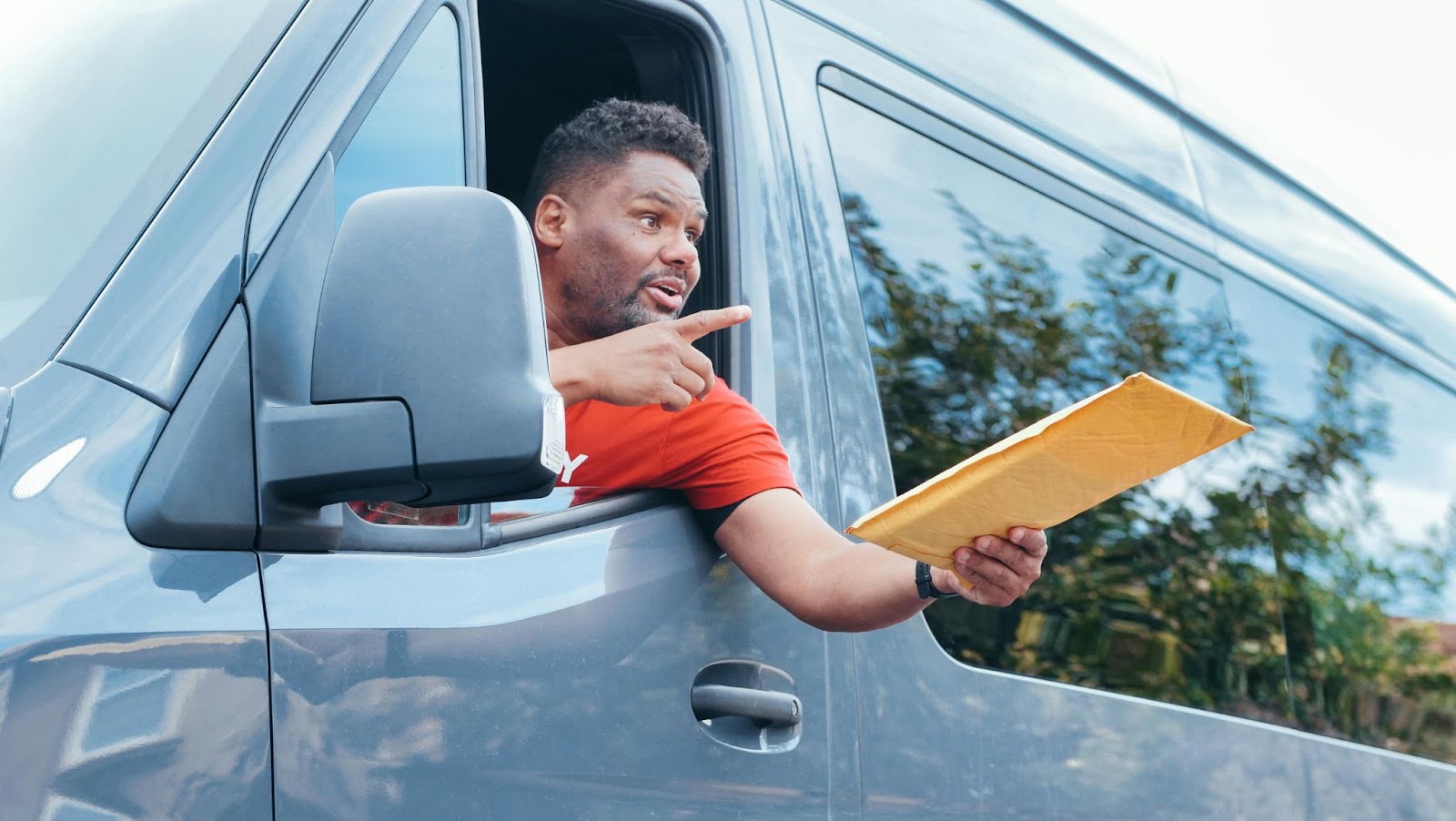 Hombre dentro de un vehículo entregando un paquete por la ventana, destacando la trazabilidad y el delivery tracking en tiempo real.