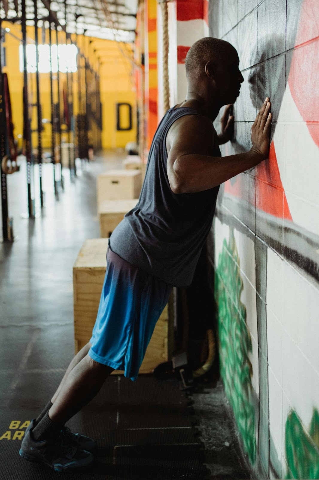 A man doing a stand-up push up on a muraled wall