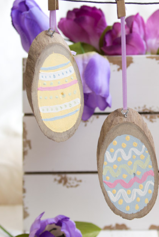 easter egg hunt ideas, painted wood slice easter eggs hanging from clothes pins