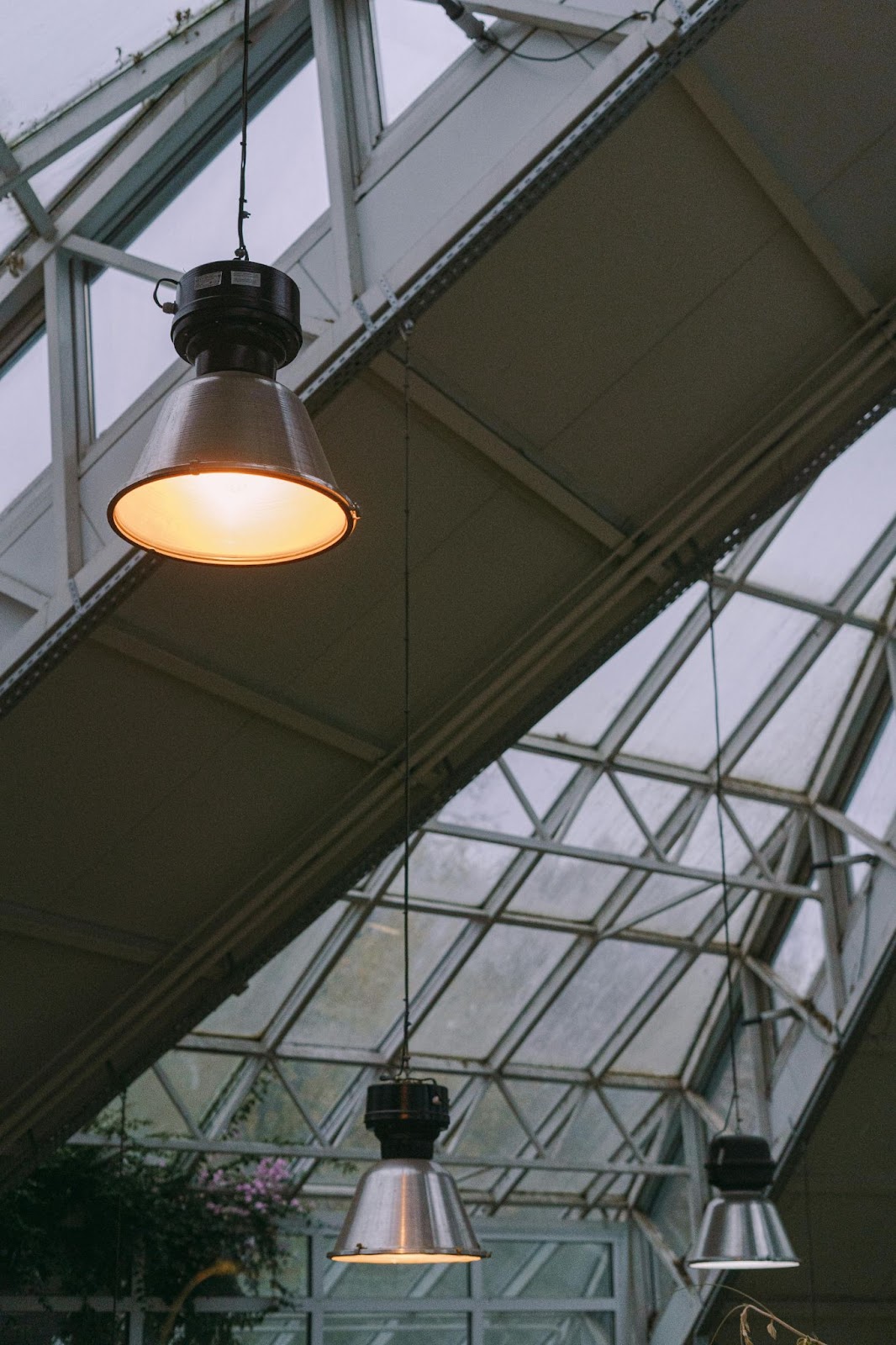 A modern prefab metal building with overhead lamps and windows.