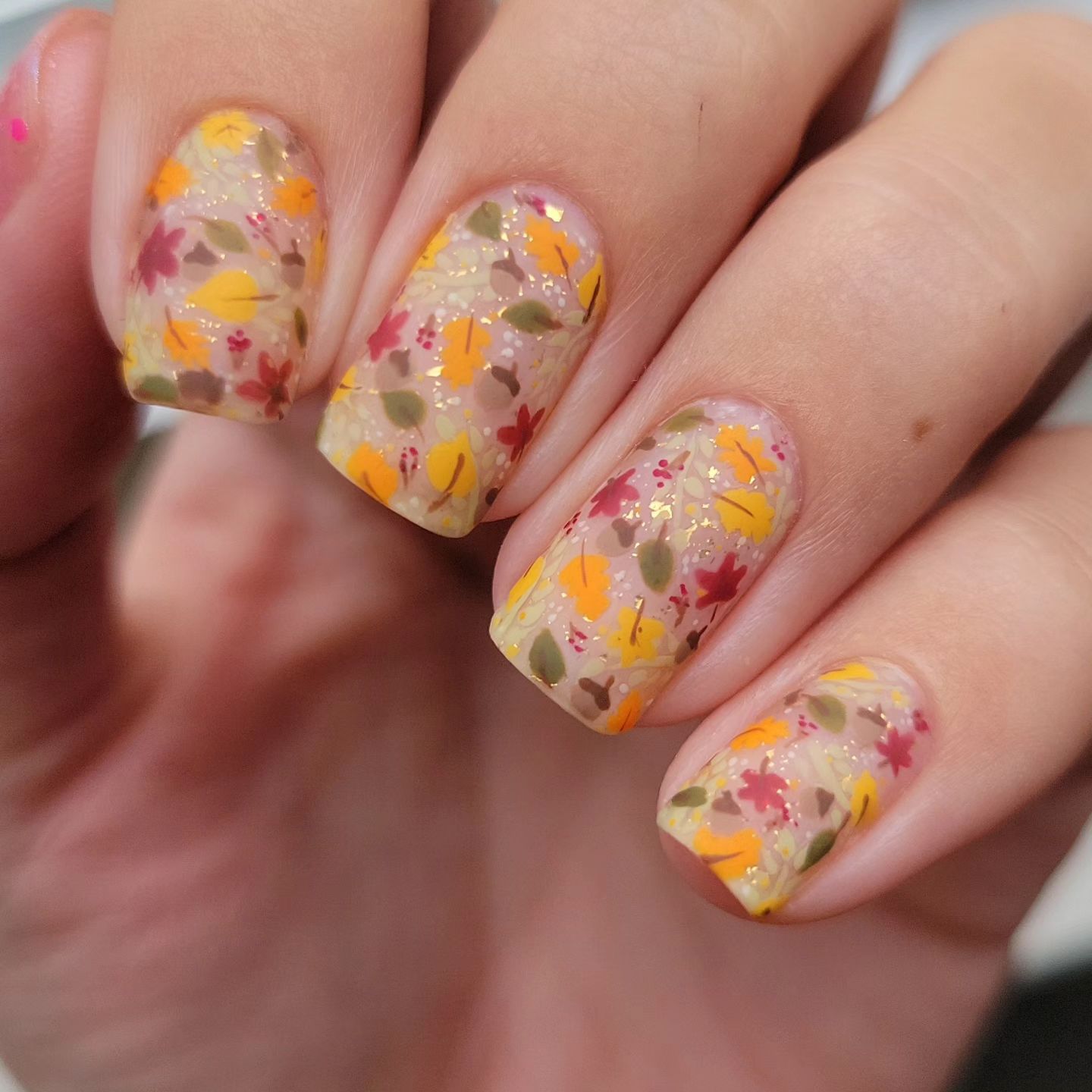 Close up of nails with glittery orange nails having Autumn Orange Leaves