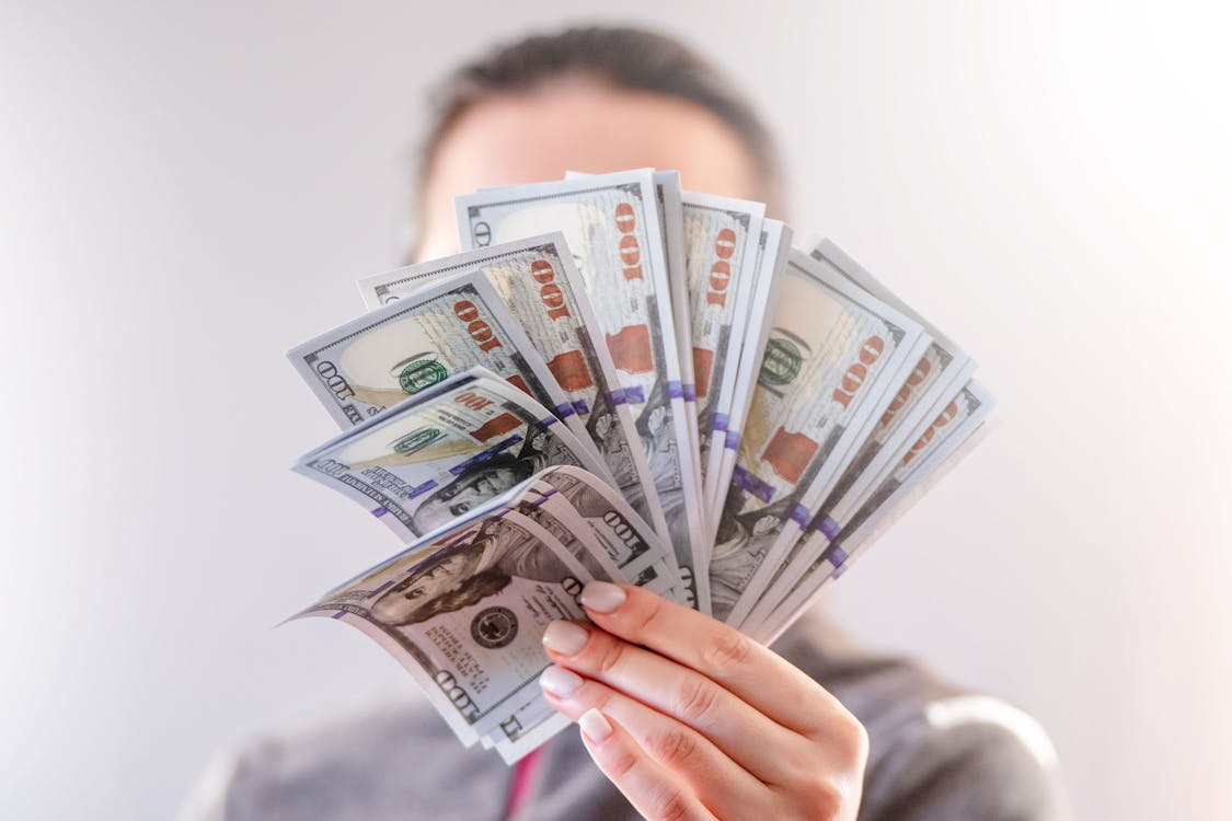 Somebody holding a lot of money up to the camera.