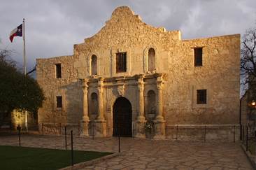 A stone building with a door with Alamo Mission in San Antonio in the background

AI-generated content may be incorrect.