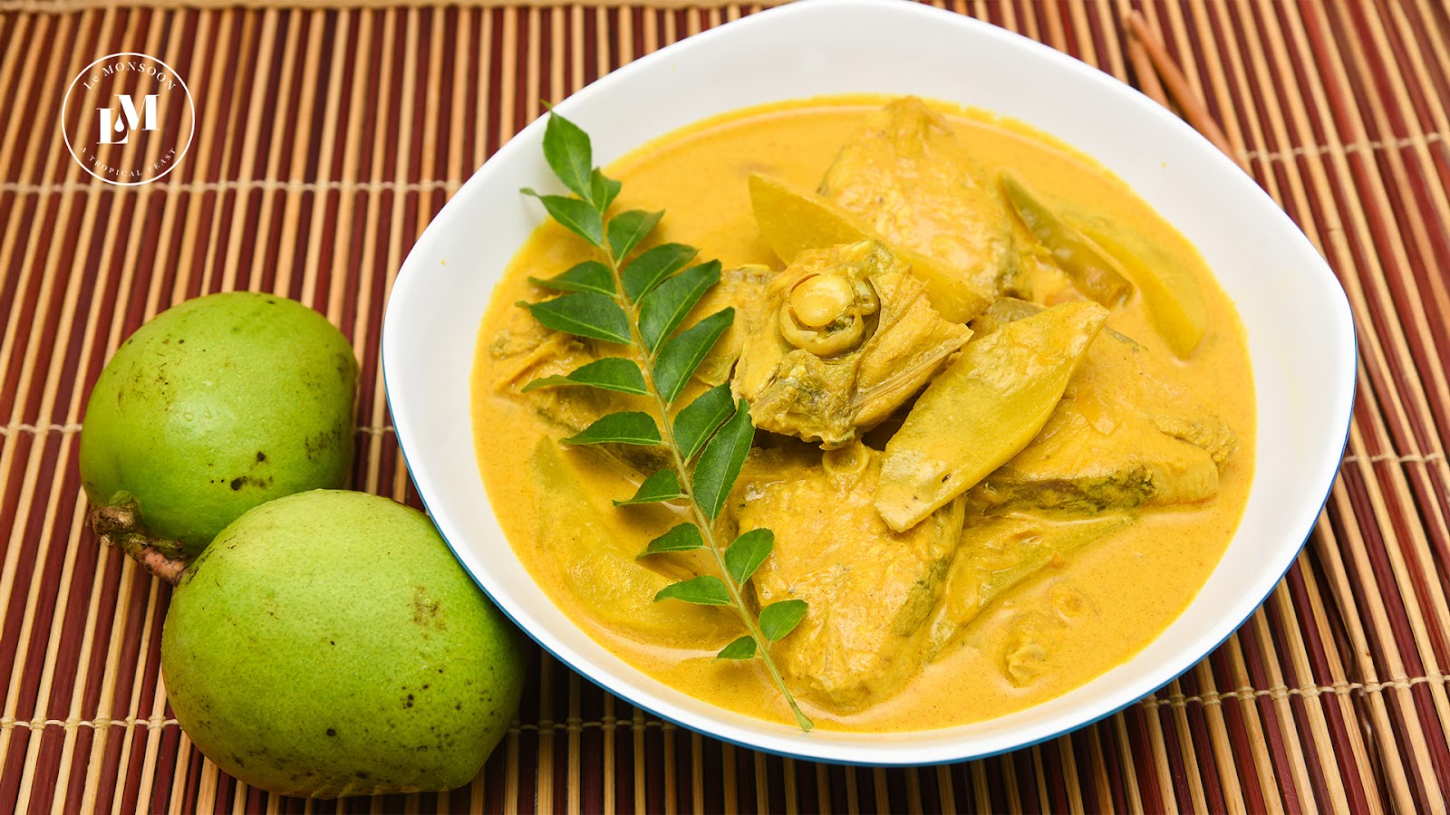 A vibrant silver bowl filled with warm fish mobile curry.