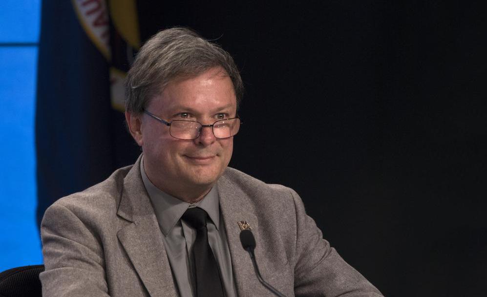 A headshot of David Brady with a black backdrop.